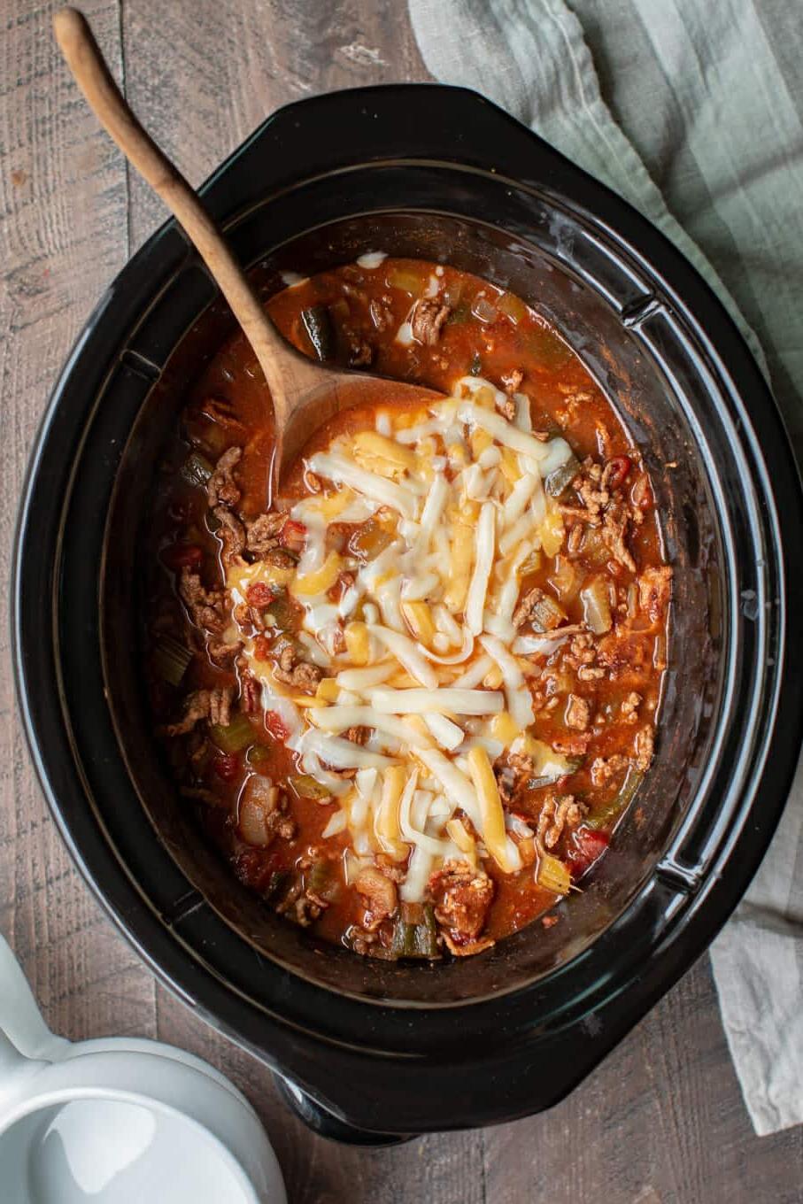 Chili di Pancetta e Manzo Low-Carb Cotto Lentamente 2 chili low carb nella slow cooker con cucchiaio di legno