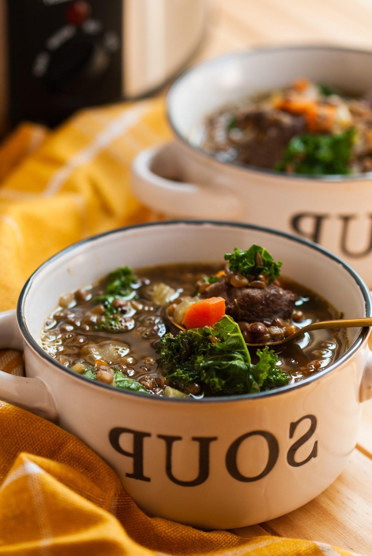 slow cooker beef and lentil soup in bowls.
