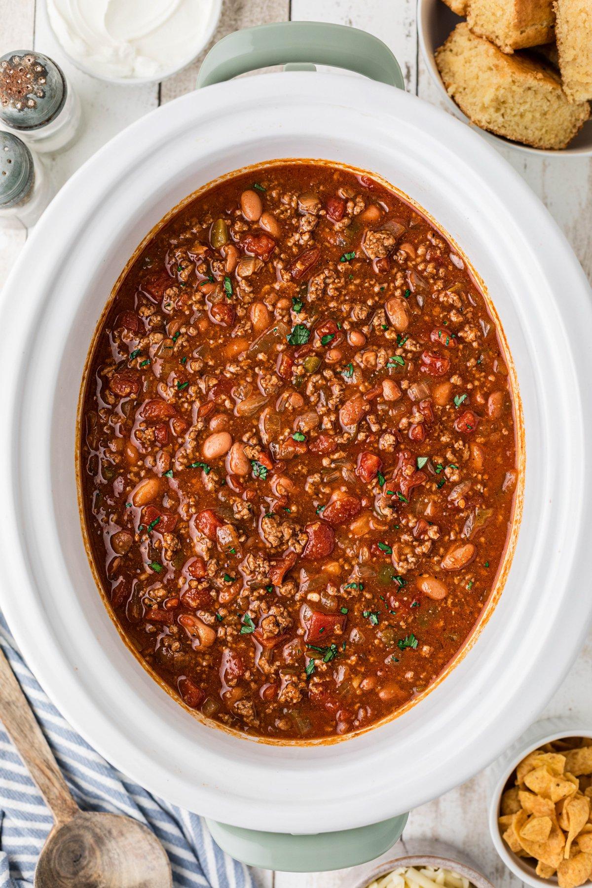 Miglior Chili per Slow Cooker 2 Pentola Crock-Pot piena di chili con cornbread sul lato.