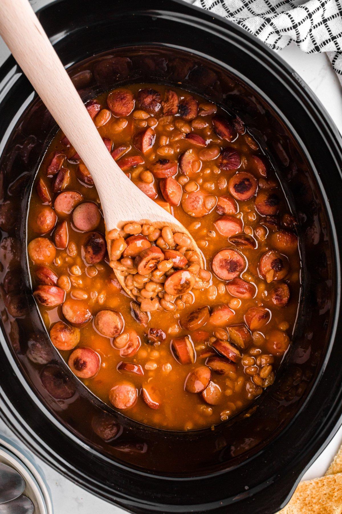 Berretti e Würstel 2 Fagioli e Würstel cotti nella slow cooker, serviti in una ciotola.