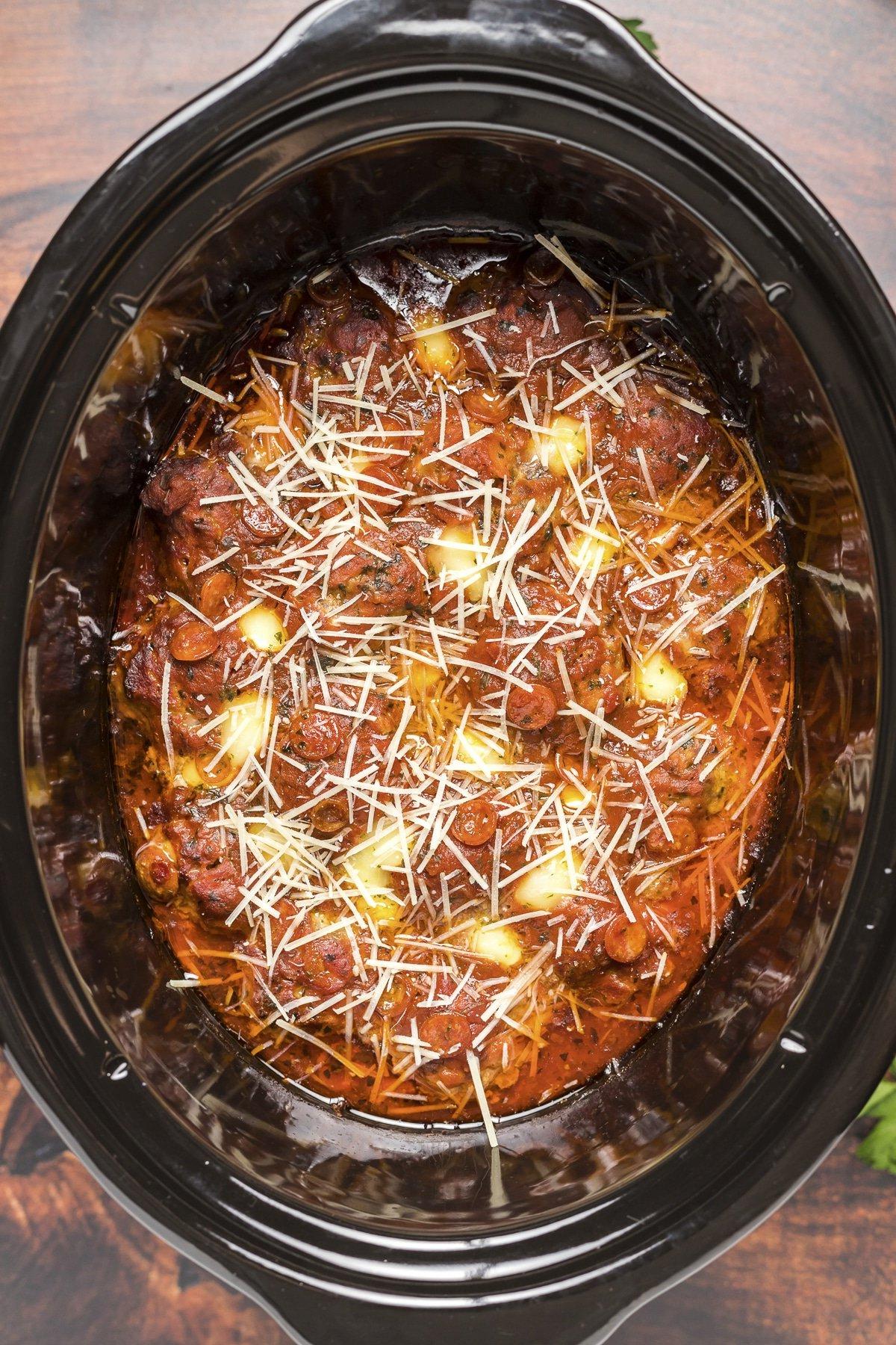 Polpette di Pizza a Cottura Lenta 2 Primo piano di polpette al sapore di pizza con parmigiano grattugiato fresco in cima, pronte per essere gustate.