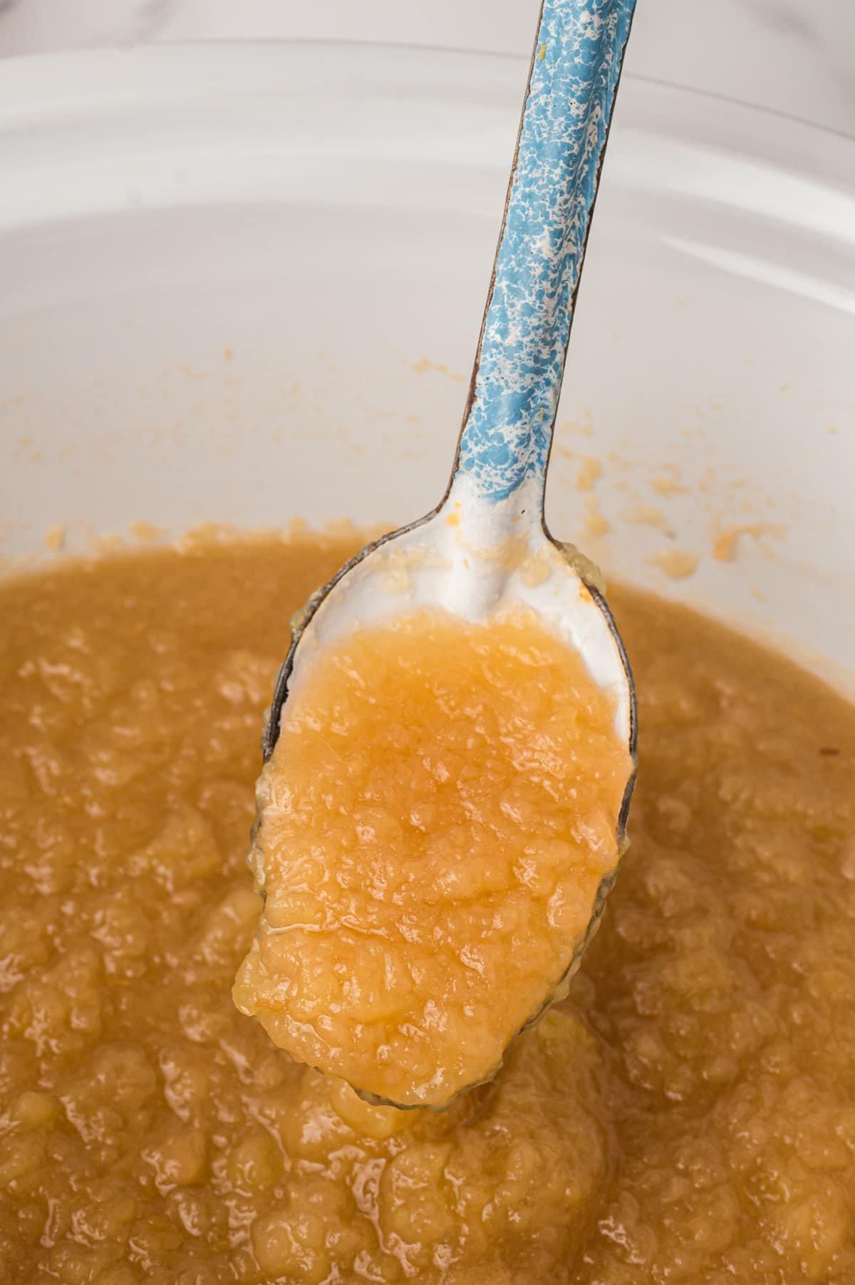 Salsa di mele a cottura lenta 2 Salsa di mele su un cucchiaio nella slow cooker.