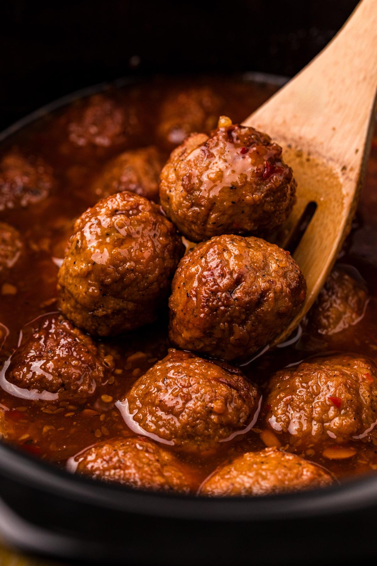 Polpette al Jalapeño in Slow Cooker 2 Raccogliere le polpette al jalapeño da una slow cooker con un mestolo.