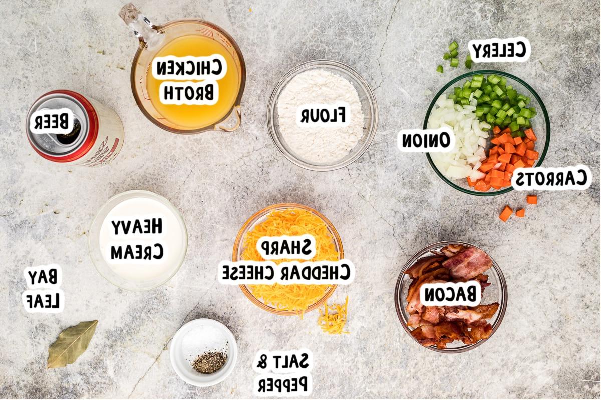 Zuppa alla birra e al formaggio 3 Ingredienti per la zuppa di formaggio e birra su un tavolo.