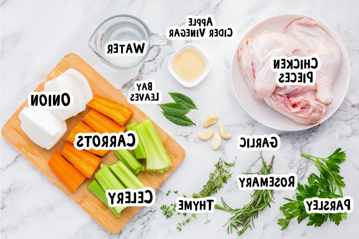 Brodo di Pollo a Cottura Lenta 3 Ingredienti freschi per il brodo di pollo, tra cui verdure e erbe, disposti ordinatamente su un piano di lavoro.