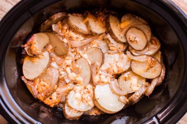 11 Contorni Facili con la Slow Cooker 3 Patate a fette con formaggio e cipolle in una slow cooker.