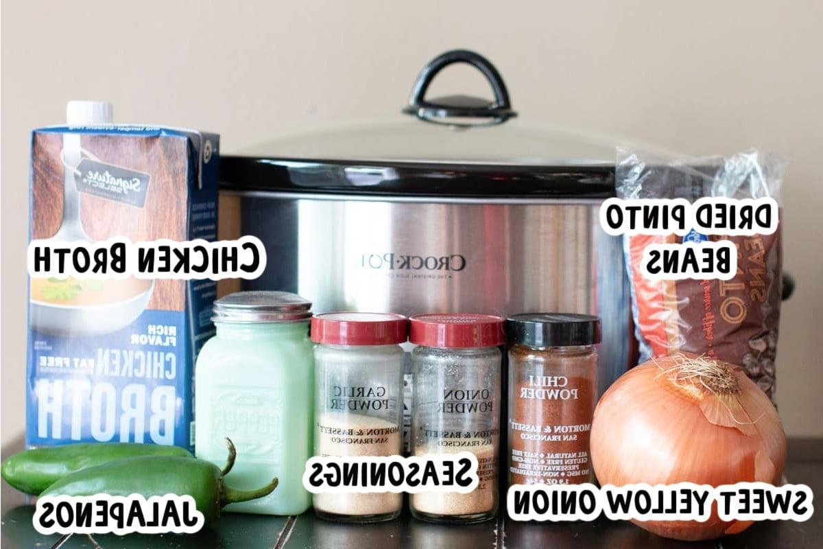 Fagioli Pinto Piccanti in Pentola a Cottura Lenta 3 Ingredienti freschi per fagioli pinto piccanti posizionati di fronte a una slow cooker.