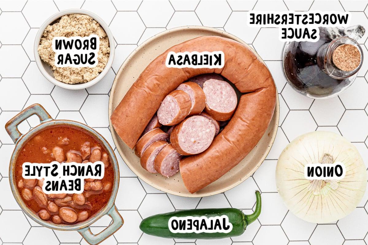 Ingredienti per fagioli e salsicce su un tavolo.