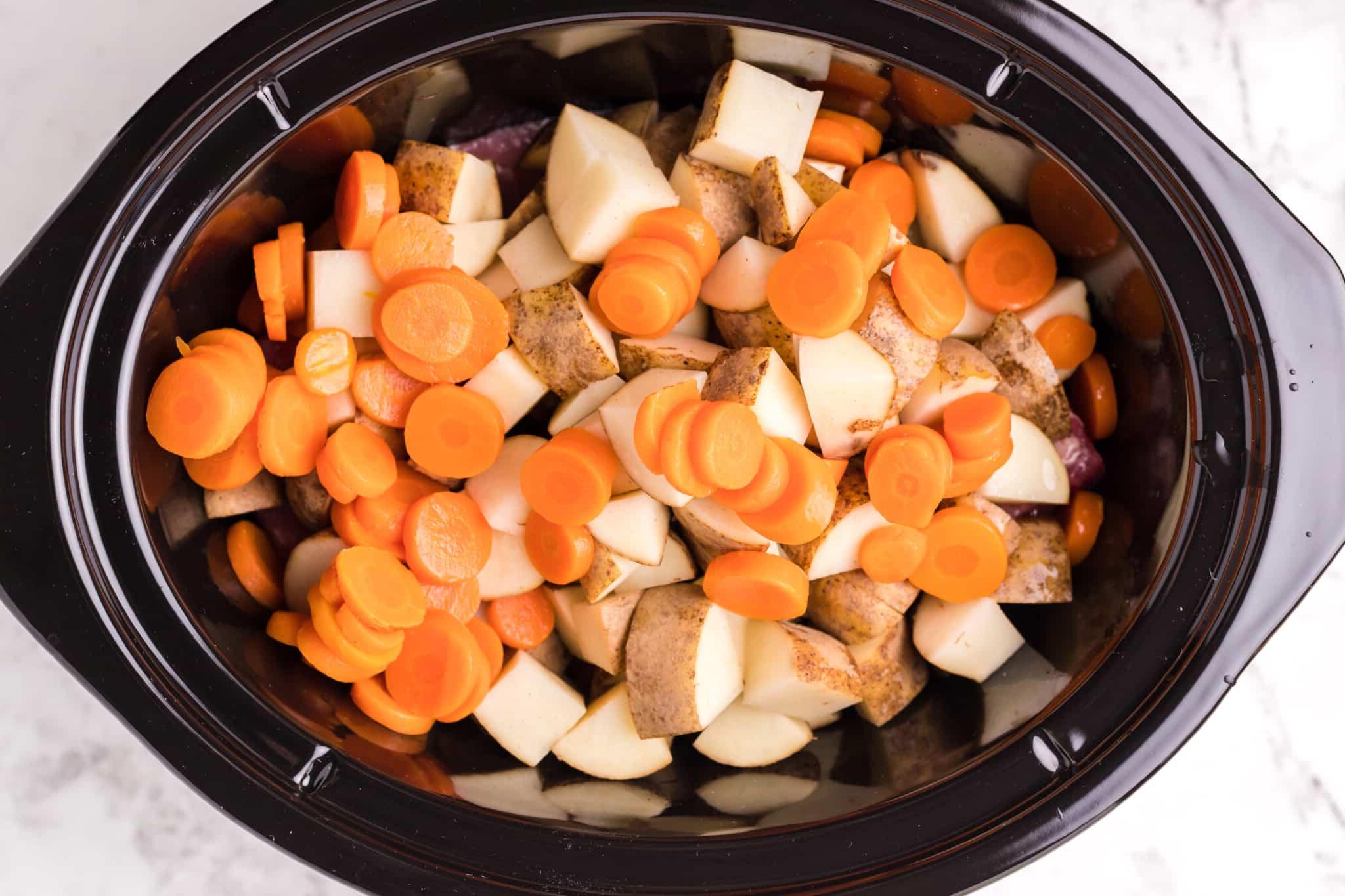 Zuppa Cremosa di Manzo in Salamoia e Cavolo Cotta Lentamente 4 carote, patate e manzo salmistrato in una slow cooker.