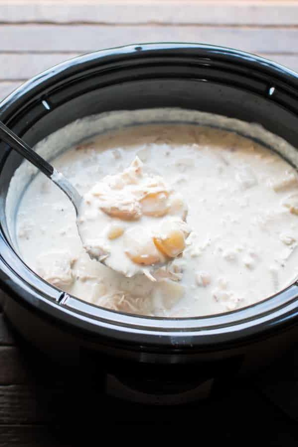 Zuppa Ricca di Pollo, Bacon e Patate in Slow Cooker 4 Mestolo di zuppa di patate e pollo che esce da una slow cooker.
