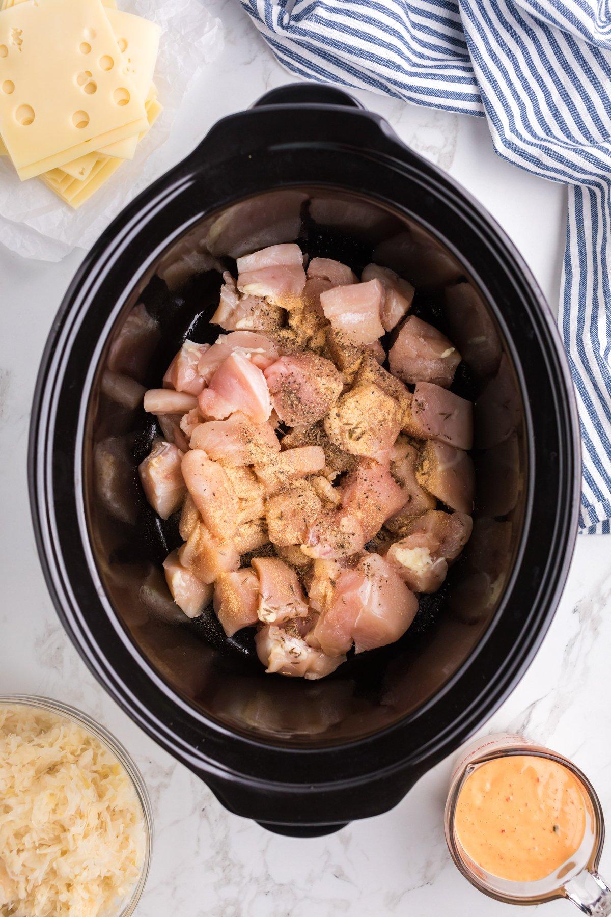 Casseruola di Pollo alla Reuben a Cottura Lenta 4 Pollo e condimenti nella slow cooker.