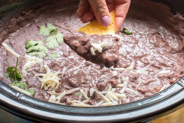 11 Contorni Facili con la Slow Cooker 4 Fagioli neri fritti raccolti da una slow cooker con una patatina.