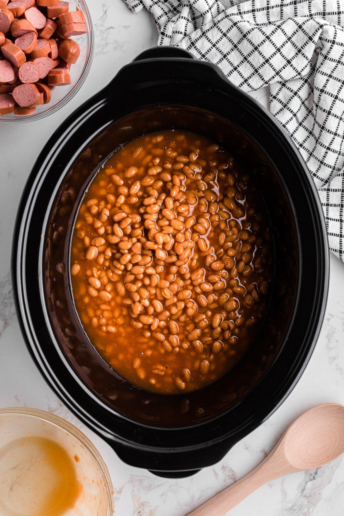 Berretti e Würstel 4 Fagioli al sugo di maiale in lattina versati nella slow cooker.