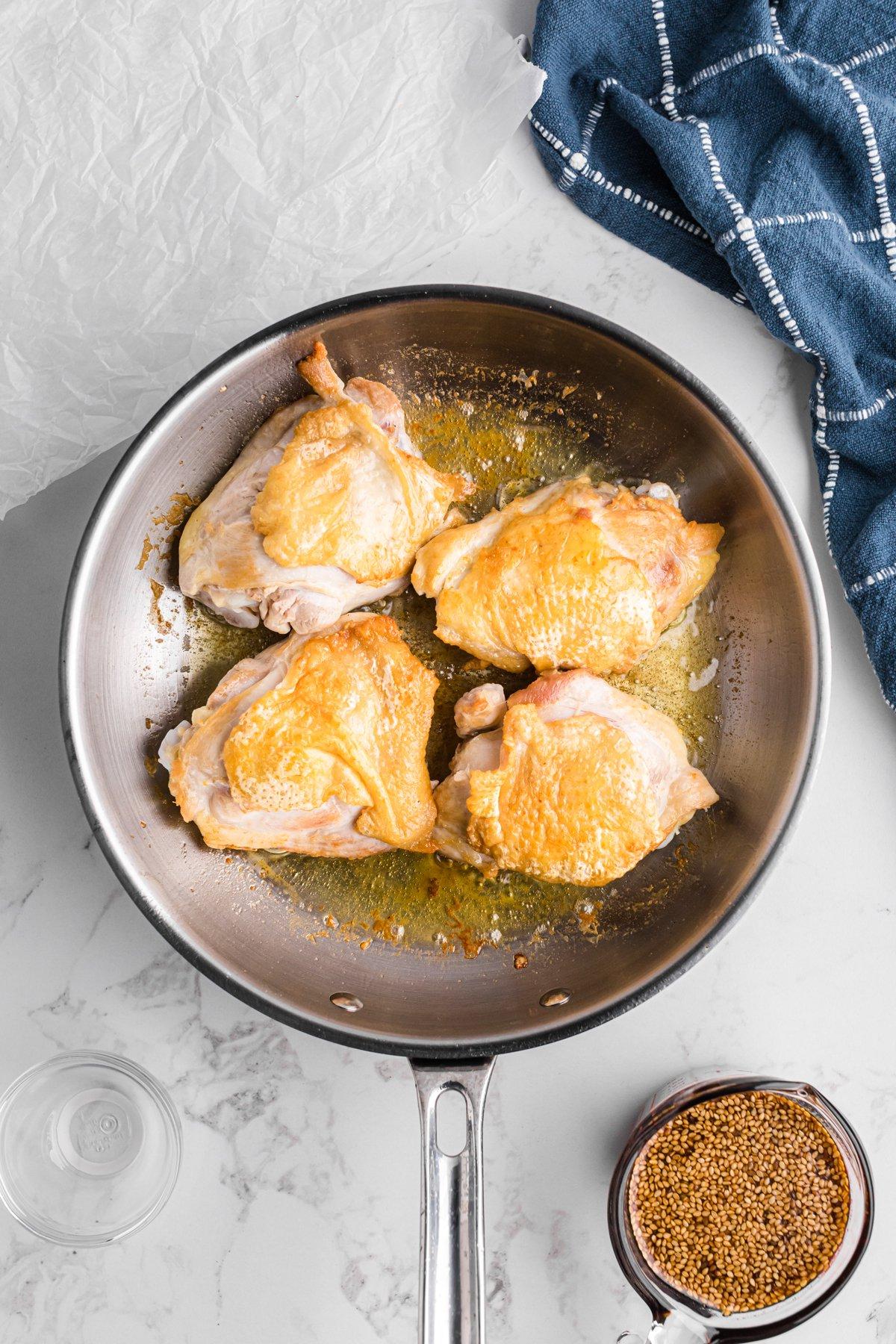 **Cosce di Pollo Teriyaki a Cottura Lenta** 4 Cosce di pollo rosolate in una padella.