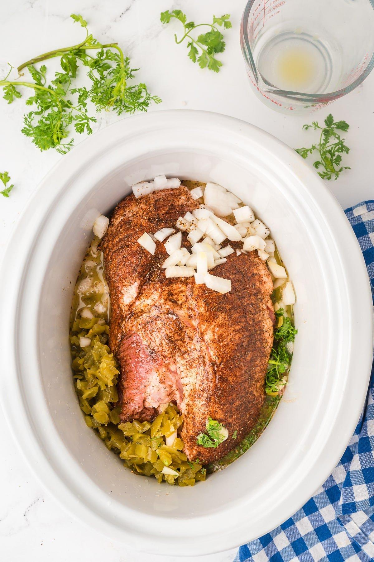 Carnitas nella Pentola a Cottura Lenta 4 Pork shoulder with seasonings, citrus juice, onion and chiles in a slow cooker.