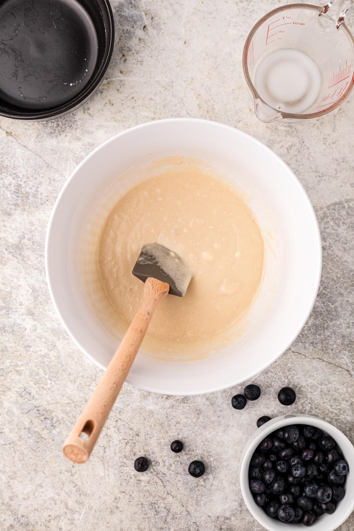**Cobbler ai Mirtilli della Slow Cooker** 4 Impasto del cobbler in una ciotola con una spatola.