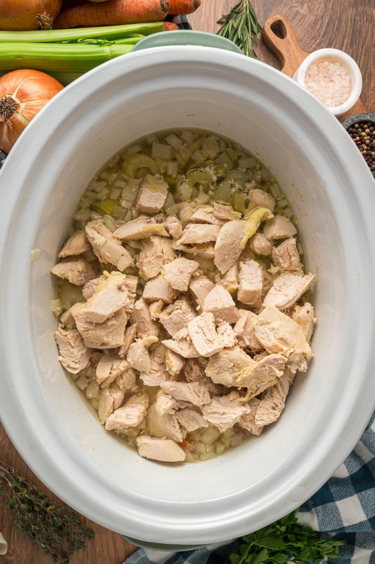 Stufato di Pollo a Cottura Lenta 5 Pollo cotto tagliato a pezzi in una slow cooker.