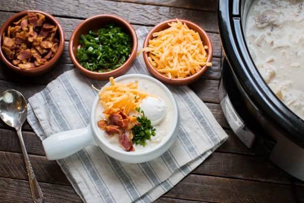 Zuppa Ricca di Pollo, Bacon e Patate in Slow Cooker 5 Ciotola di zuppa con guarnizioni in ciotoline a lato.