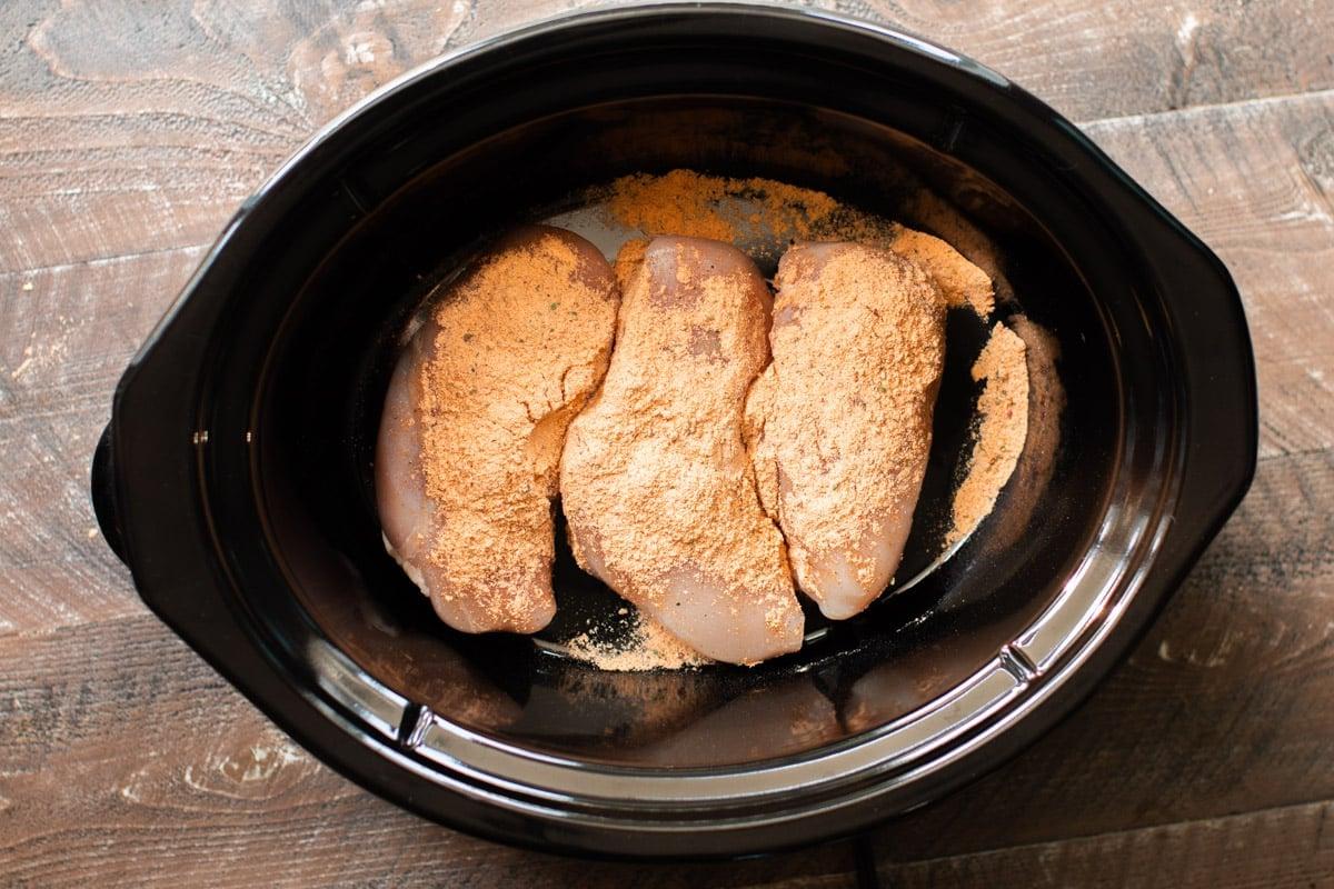 Pollo Fiesta in Slow Cooker 5 petti di pollo con condimento fiesta sopra.
