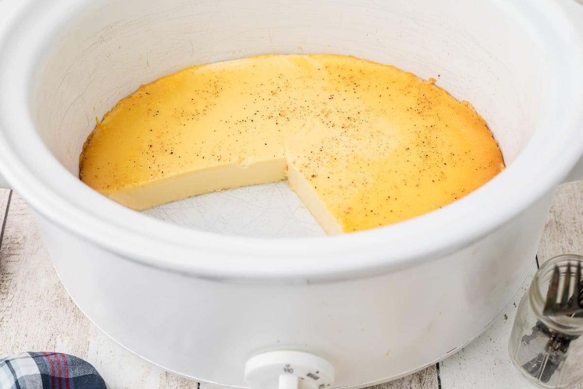 budino al forno in crockpot con una fetta tagliata.