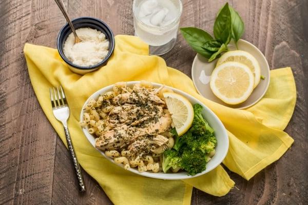 Pollo al Pesto e Limone in Slow Cooker {Congelabile} 6 Noodles ricci, pollo, broccoli e limone in una ciotola ovale.