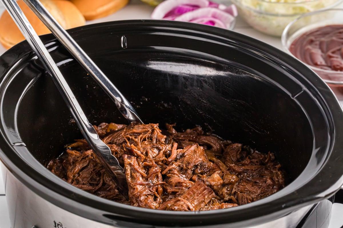 Manzo al Barbecue a Lenta Cottura 6 Vista laterale del manzo BBQ in una slow cooker.
