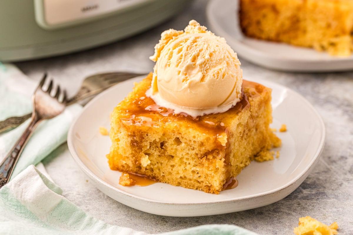Torta al Caramello a Cottura Lenta 6 fetta di torta al caramello slow cooker su un piatto con gelato sopra.