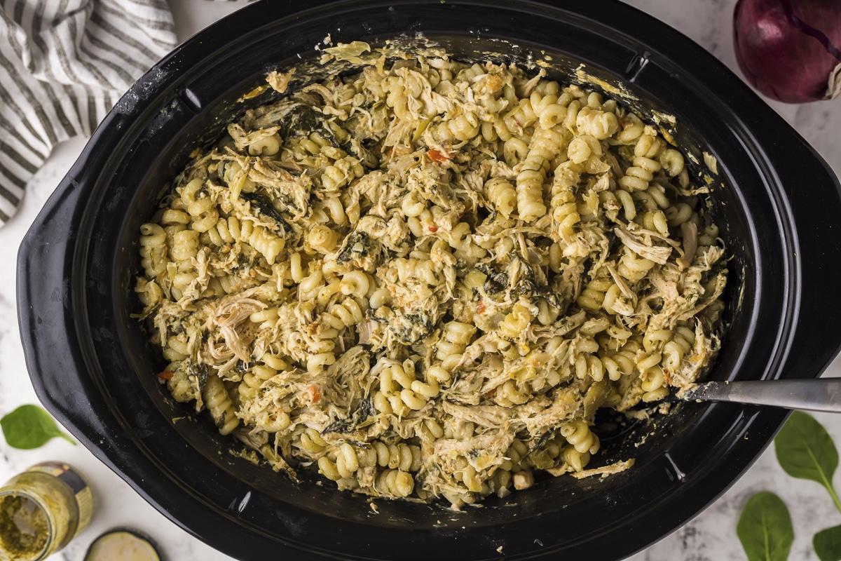 pasta di pollo spinaci e carciofi nella slow cooker con cucchiaio