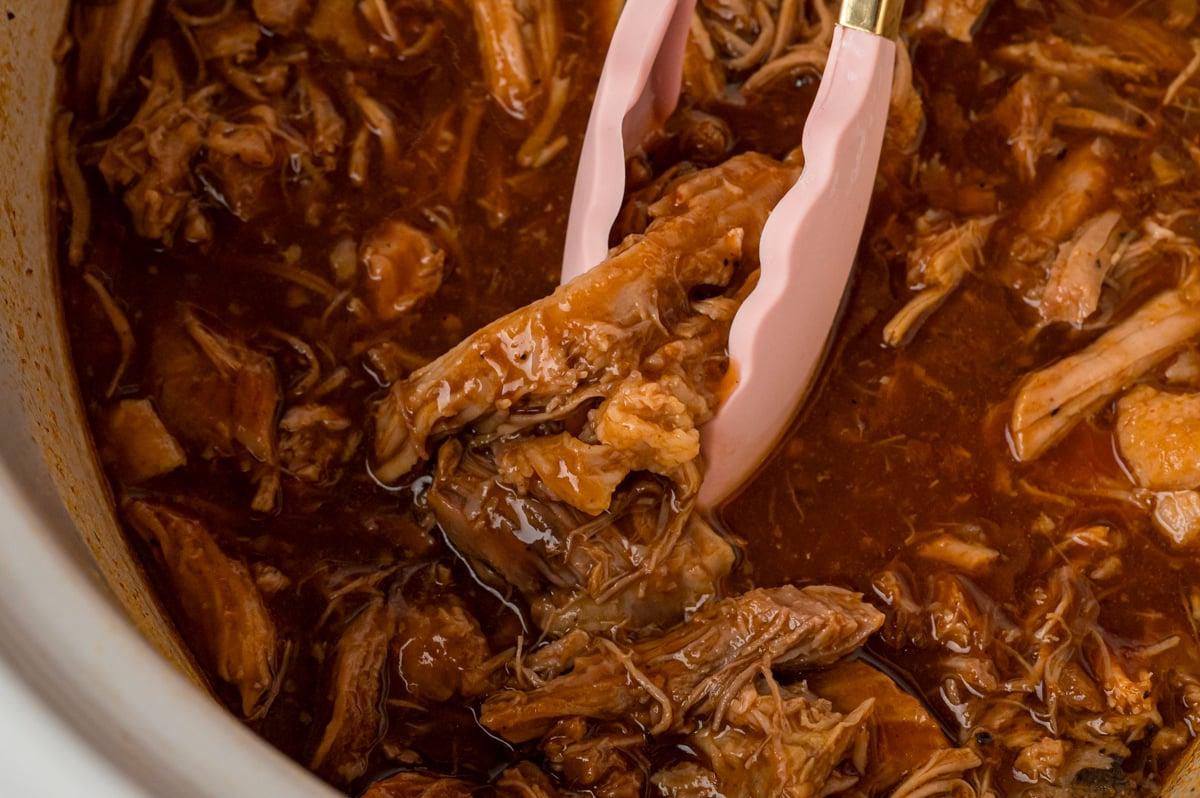 Maiale Sfilacciato al Dr. Pepper 6 Primo piano dall'alto di maiale sfilacciato al Dr. Pepper in slow cooker.