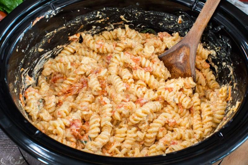 Cene Slow Cooker per il Rientro a Scuola 6 pasta con pomodoro e feta in slow cooker con cucchiaio di legno