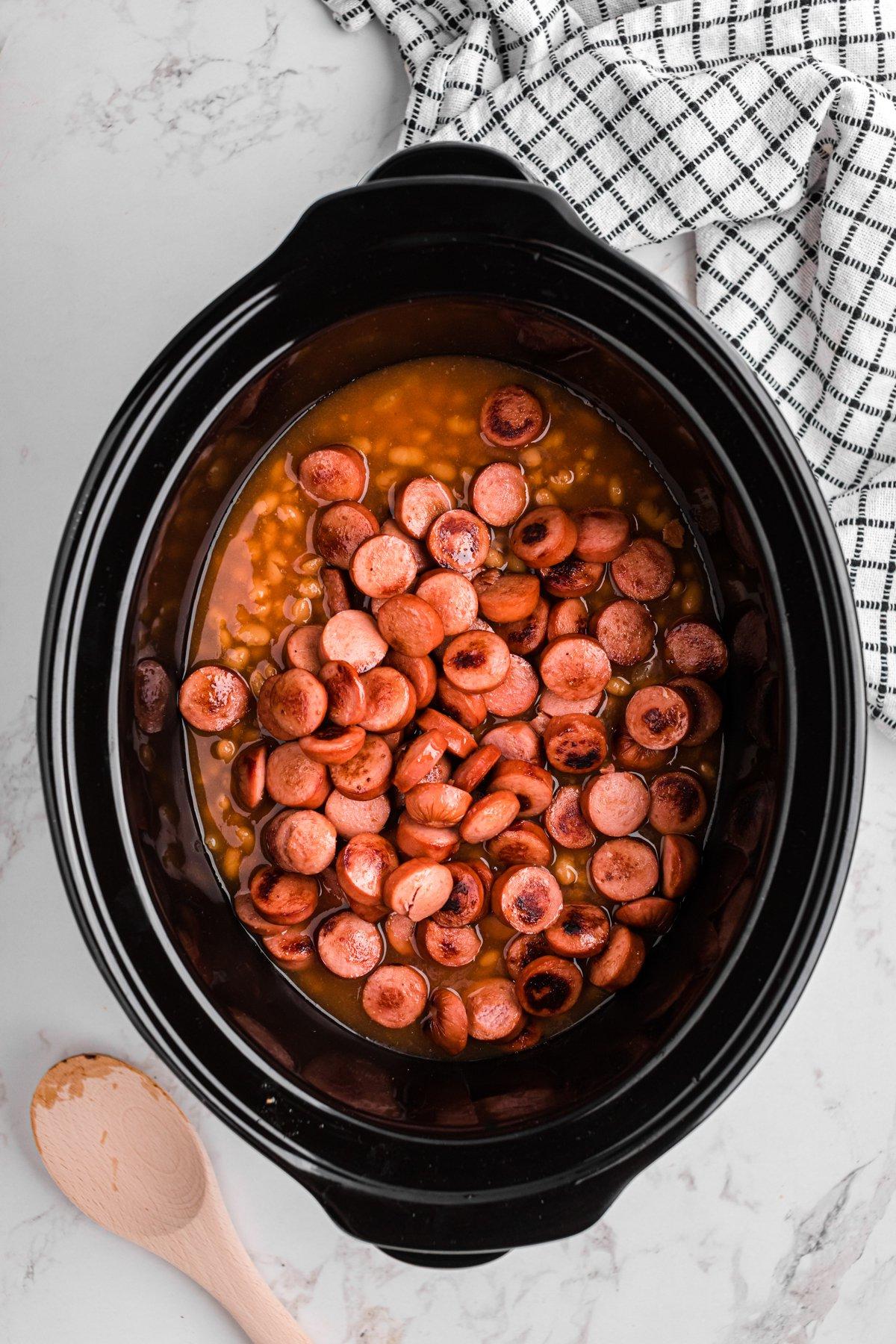 Berretti e Würstel 6 Würstel aggiunti nella slow cooker insieme ai fagioli.