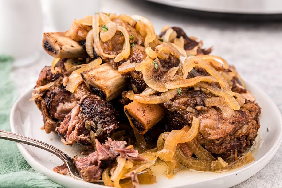 Piatto di costolette di birra e cipolla con cipolle sopra.