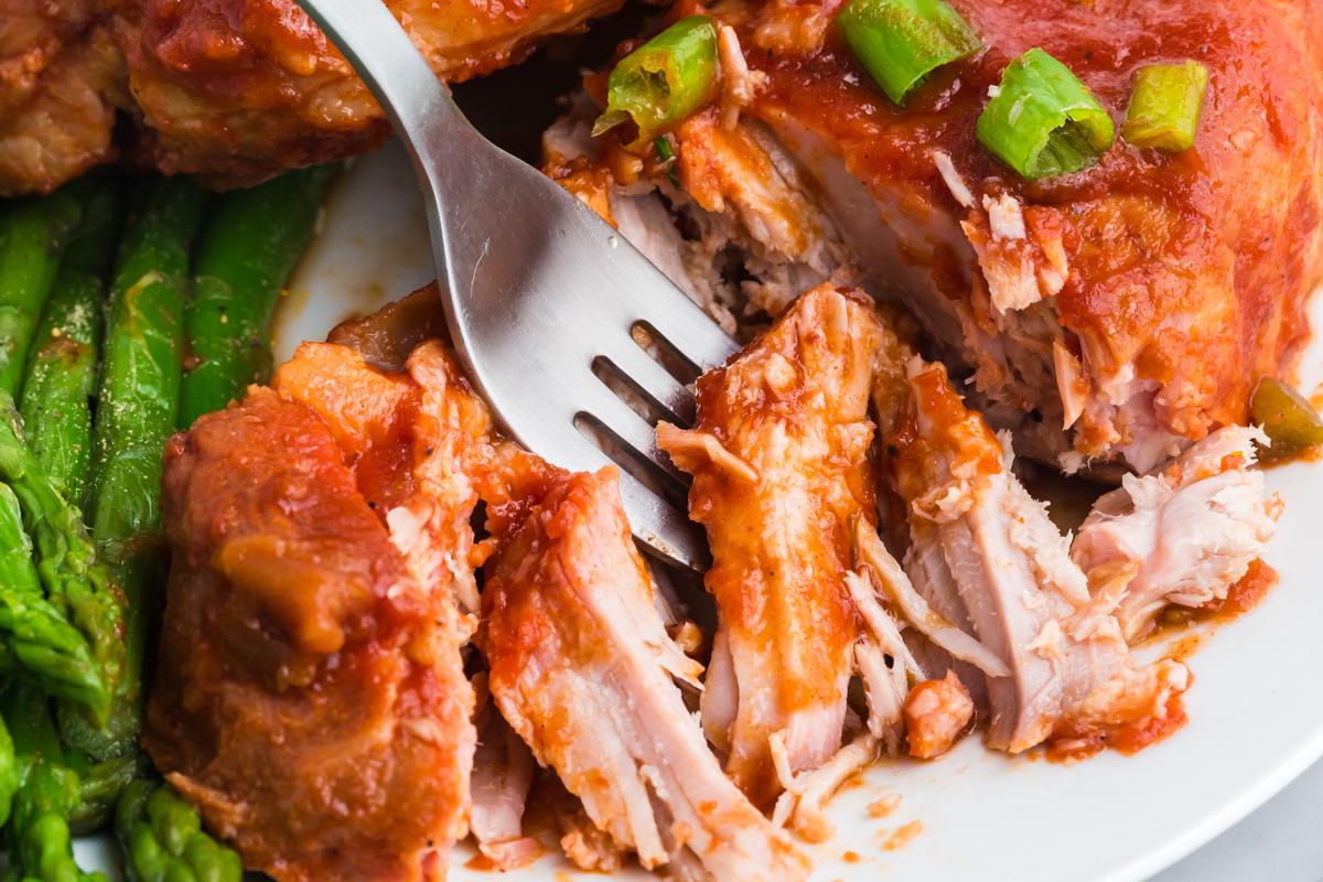 Costolette di Maiale al Barbecue in Slow Cooker 6 Forchetta che taglia una porzione di costolette di maiale al barbecue in slow cooker.