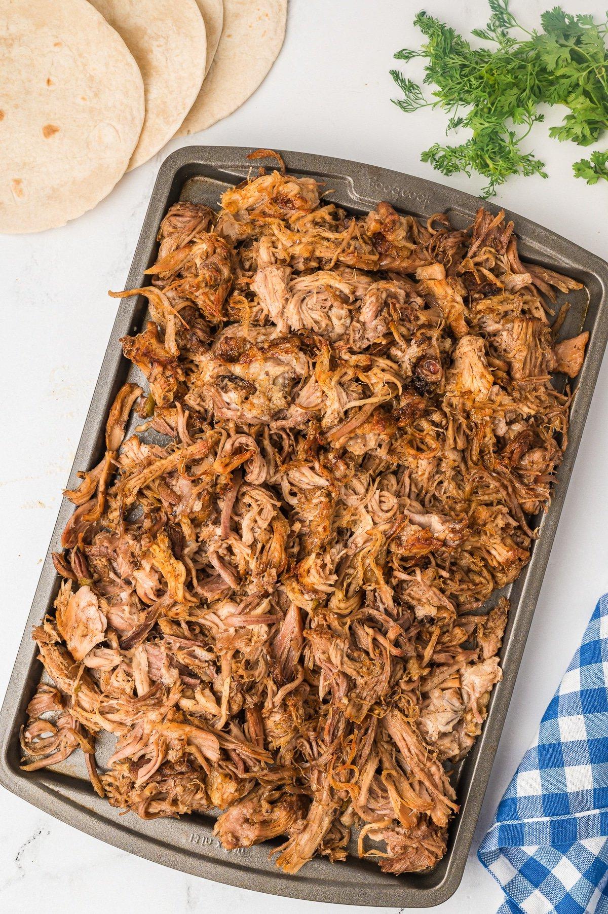 Carnitas nella Pentola a Cottura Lenta 6 Carnitas being crisped on a sheet pan.