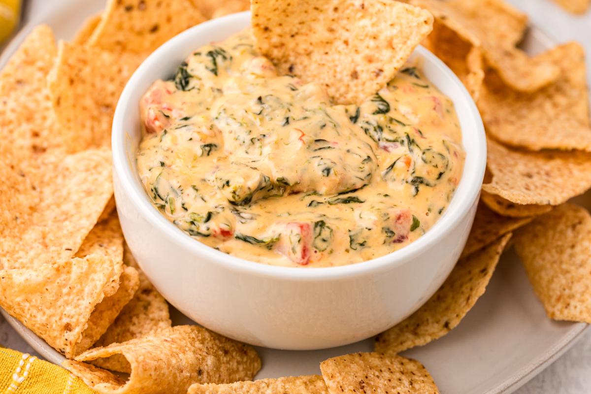 Salsa di Formaggio e Spinaci a Lenta Cottura 6 ciotola di queso spinaci dip con chip al suo interno.