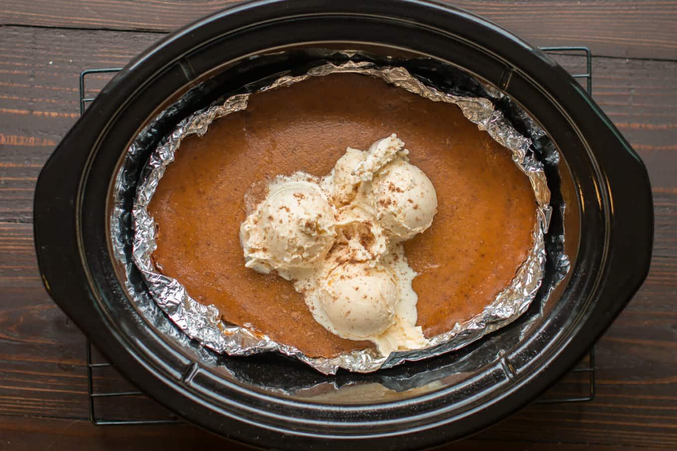 Torta di Zucca Senza Crosta allo Zucchero di Canna a Cottura Lenta 6 Torta di zucca cotta nella slow cooker con 3 palline di gelato sopra.