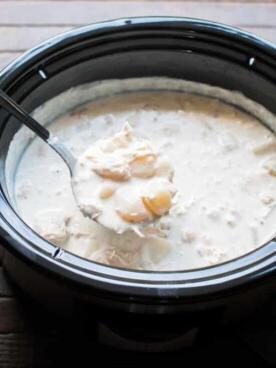 Zuppa Ricca di Pollo, Bacon e Patate in Slow Cooker 7 Mestolo di zuppa di patate e pollo che esce da una slow cooker.