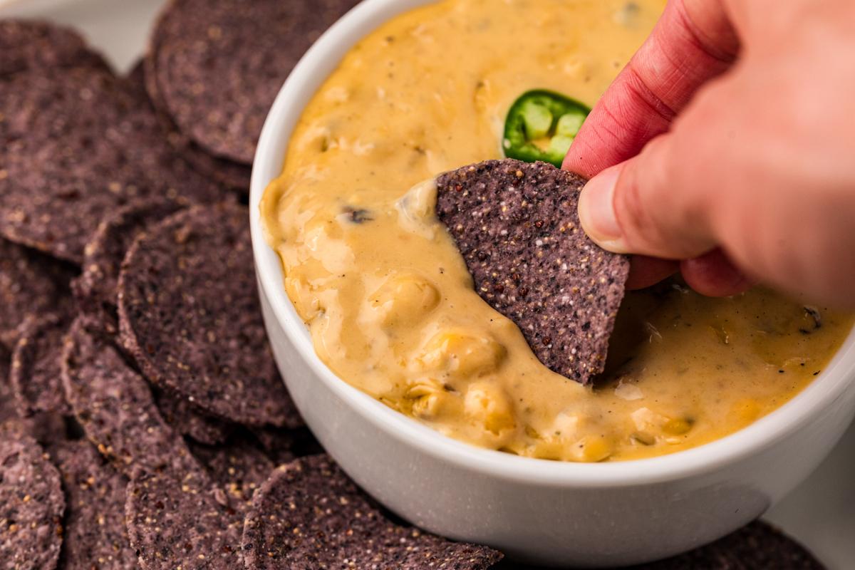 Un chip che viene intinto in un dip al queso.