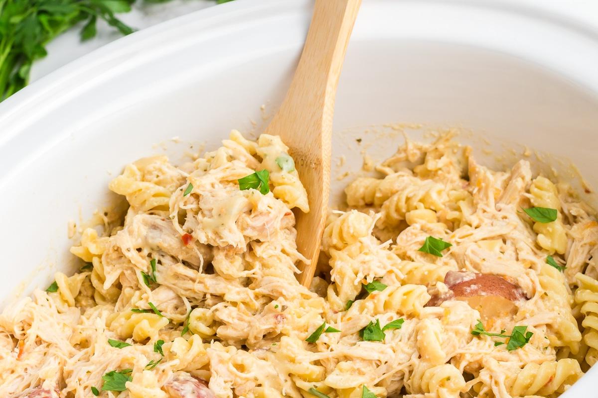 **Pollo all'Aglio e Parmigiano con Pasta a Cottura Lenta** 6 Un cucchiaio che serve una porzione abbondante di pasta rotini con pollo e aglio direttamente dalla slow cooker.