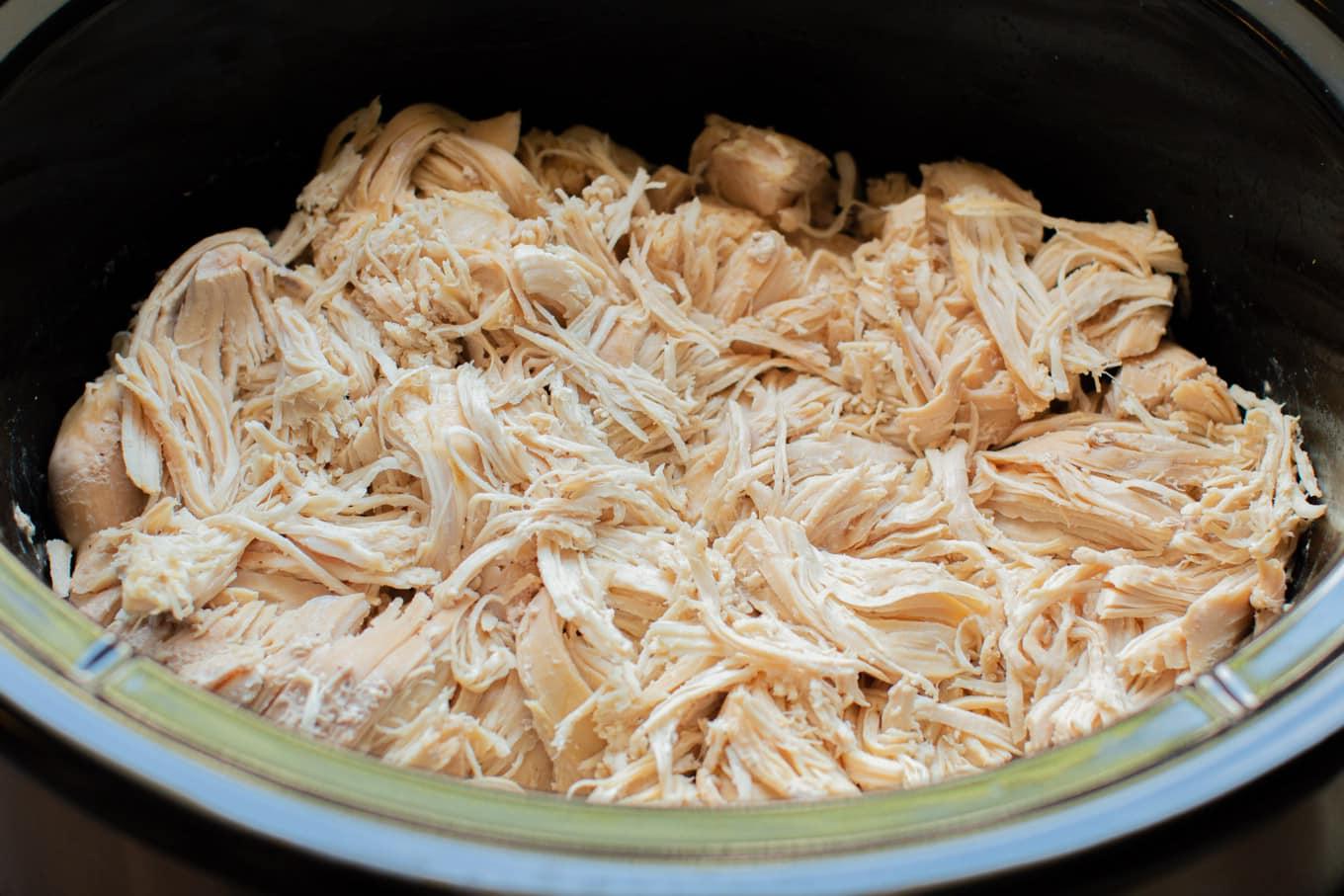 Pollo sfilacciato in slow cooker 7 primo piano del pollo sfilacciato nella pentola a cottura lenta.