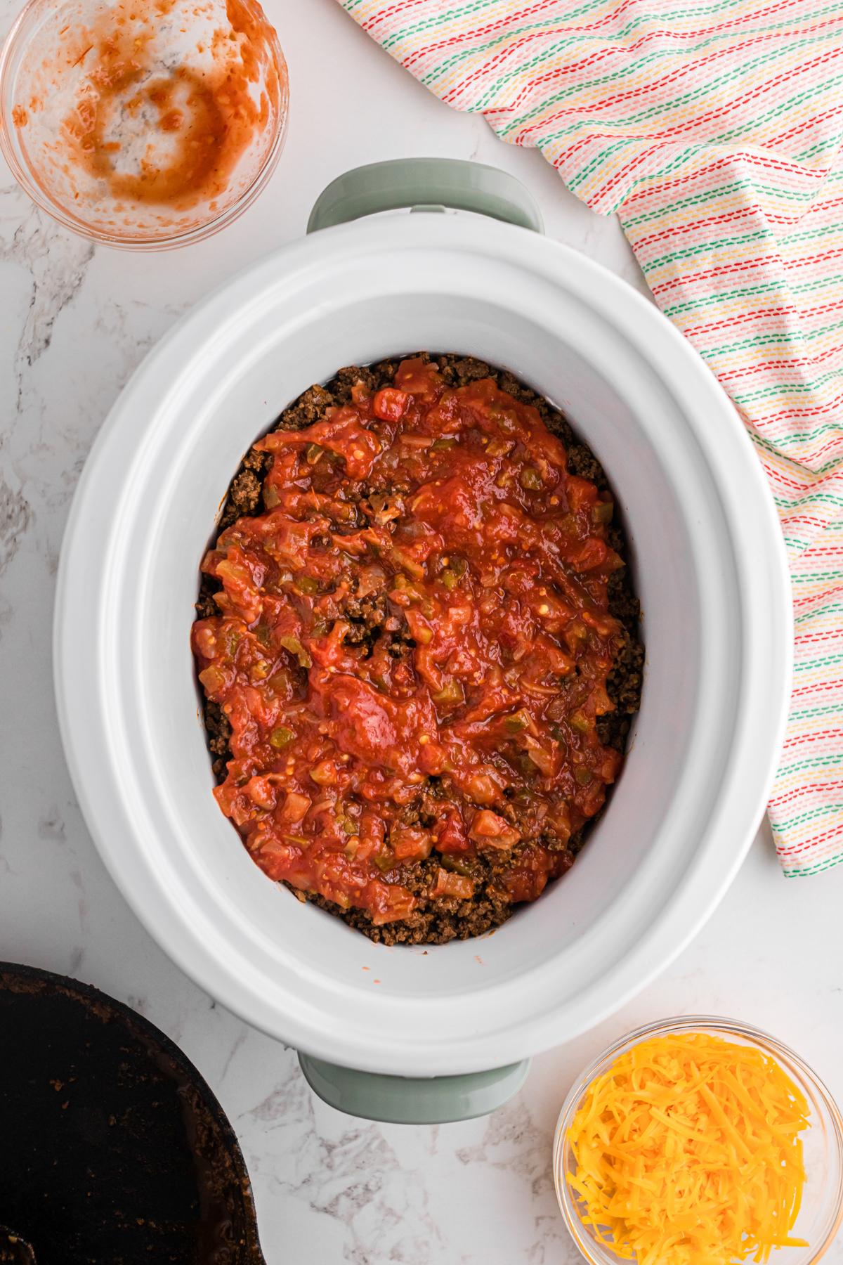Salsa della Domenica Divertente 7 Carne macinata e salsa aggiunte a un slow cooker.