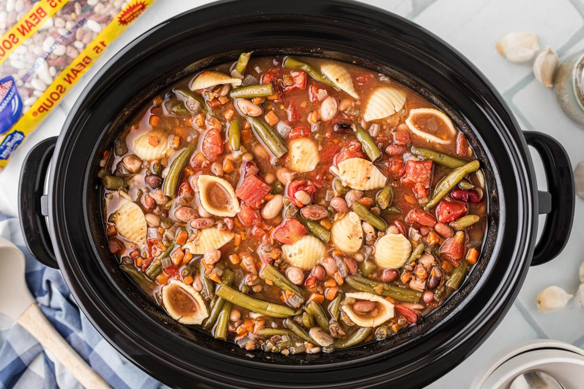 Minestrone di 15 Legumi a Cottura Lenta {Vegetariano} 7 Zuppa minestrone 15 legumi in pentola a cottura lenta con sacchetto di legumi sullo sfondo.