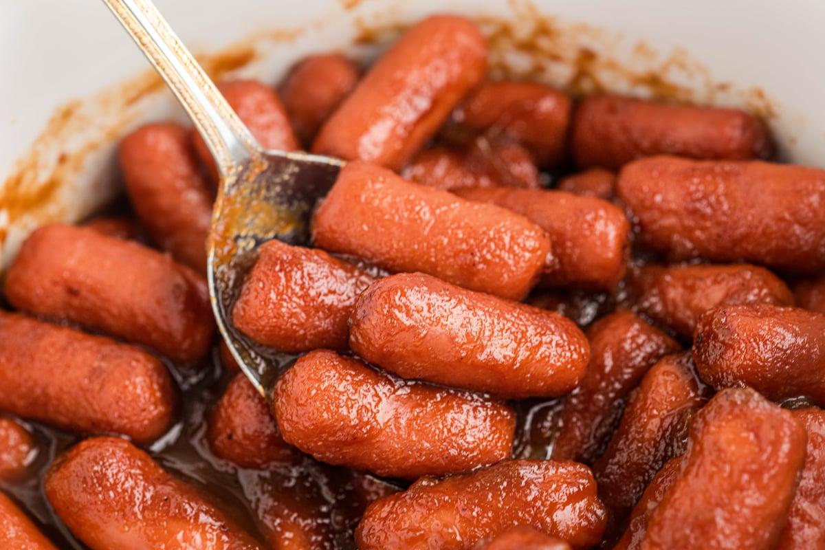 **Wurstel Piccoli al Burro di Mele in Slow Cooker** 7 Salsiccine mini al burro di mele nella slow cooker che vengono servite con un cucchiaio.