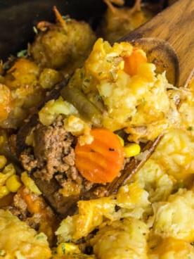 Sformato di Tater Tot alla Pastore 7 close up of shepherd's pie tater tot casserole on a wooden spoon in a crockpot.