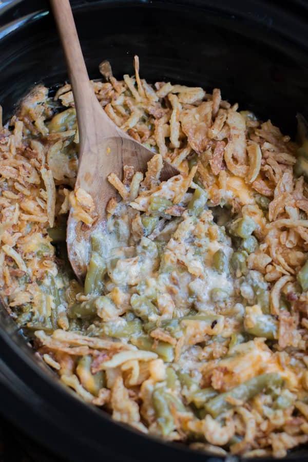 **Gratin di Fagiolini al Formaggio a Cottura Lenta** 7 Immagine ravvicinata di una porzione generosa di casseruola di fagiolini al formaggio, guarnita con abbondanti cipolle fritte croccanti e dorate, che ne esaltano la texture e il sapore.