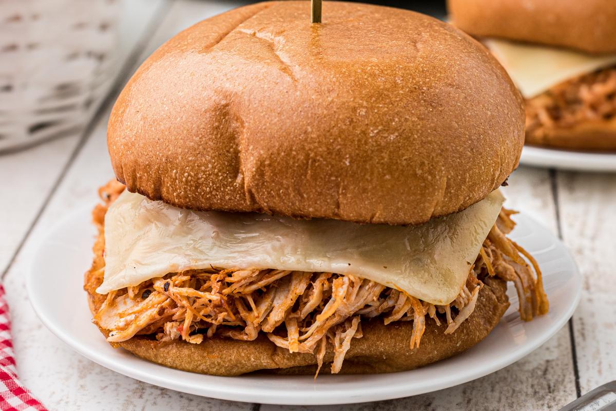 Panini al Pollo alla Parmigiana a Cottura Lenta 7 Primo piano di un panino di pollo alla parmigiana con abbondante salsa marinara e mozzarella fusa.