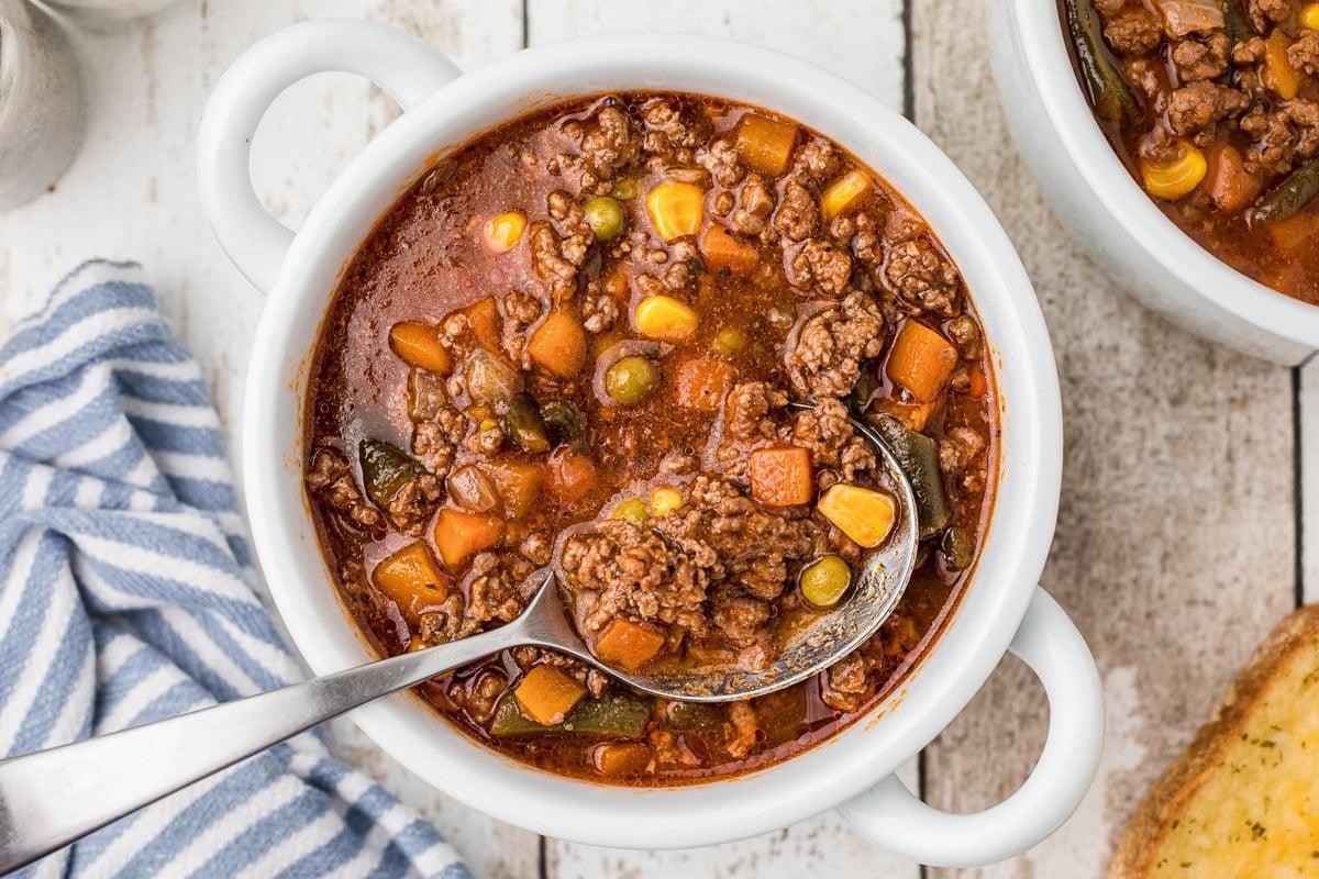 Zuppa di Hamburger a Cottura Lenta 7 Ciotola di zuppa di hamburger con un cucchiaio.
