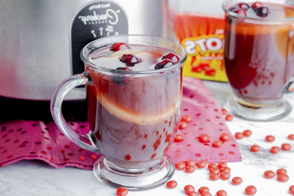 **Punch Piccante alla Cannella per Slow Cooker** 7 tazza di punch rosso caldo davanti allo slow cooker