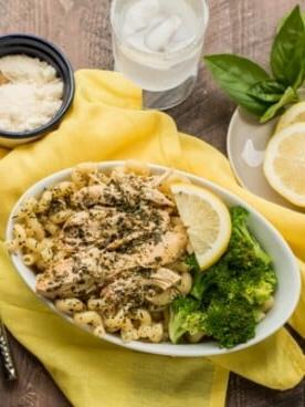 Pollo al Pesto e Limone in Slow Cooker {Congelabile} 7 Noodles ricci, pollo e broccoli in una ciotola ovale.