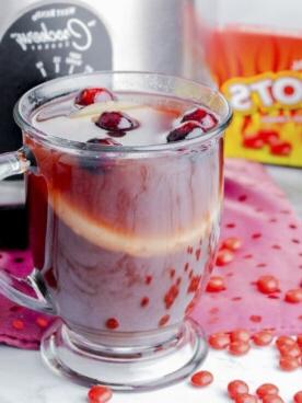**Punch Piccante alla Cannella per Slow Cooker** 8 tazza di punch rosso caldo davanti allo slow cooker